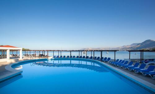 察夫塔特Remisens Hotel Epidaurus-All inclusive的一个带椅子的游泳池,背景是大海