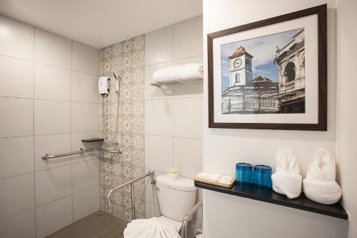 普吉镇普吉岛苏伦套房酒店的一间带卫生间的浴室,并画着钟楼的照片