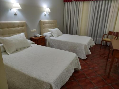 比利亚尔潘多Hotel Cañada Real的酒店客房,配有两张带白色床单的床
