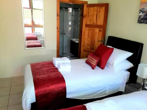 维多利亚85 Palma Living的一间卧室配有两张带红白色枕头的床