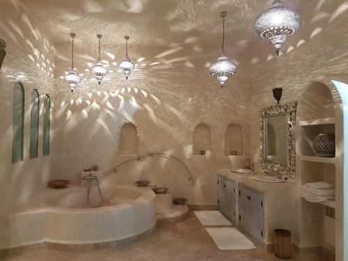 塔鲁丹特Palais Villa Talaa Resort的带浴缸、两个水槽和吊灯的浴室
