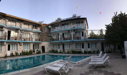 帕莫卡莱海豚尤努斯酒店的酒店设有一个游泳池和两个草坪椅
