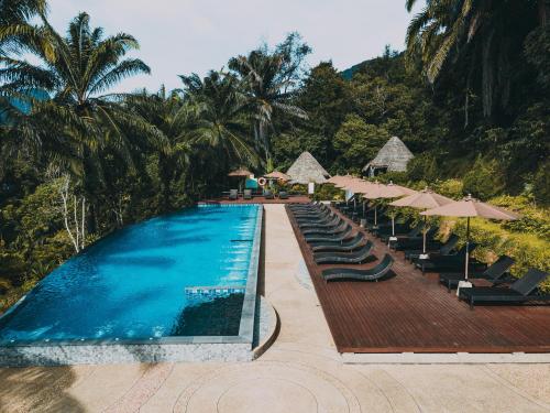 奥南海滩Aonang Fiore Resort - SHA Extra Plus的一个带躺椅和遮阳伞的游泳池