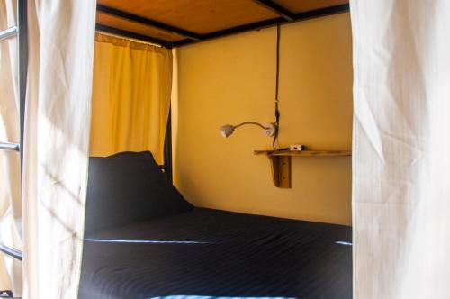 达兰萨拉Hobo Hostel的一间小卧室,配有床和灯