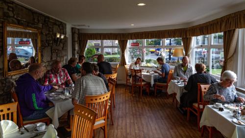皮特洛赫里阿瑟尔别墅旅馆的一群坐在餐厅桌子上的人