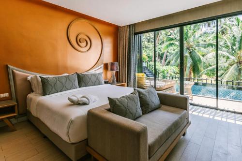 涛岛The Tarna Align Resort - SHA Plus的一间卧室配有一张床、一张沙发和一个大窗户