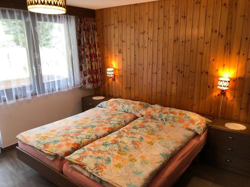 萨斯格伦德豪厄尔公寓的卧室配有一张床铺,位于带木墙的房间内