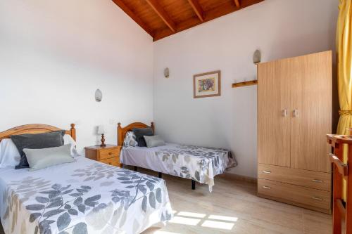 Valle de Santa InésFlatguest Chozo del viejo - Peaceful country Villa in La Antigua的一间卧室设有两张床和木制橱柜