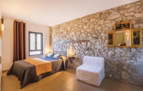 Torroella de FluviáCan Salva的一间卧室设有一张床和石墙