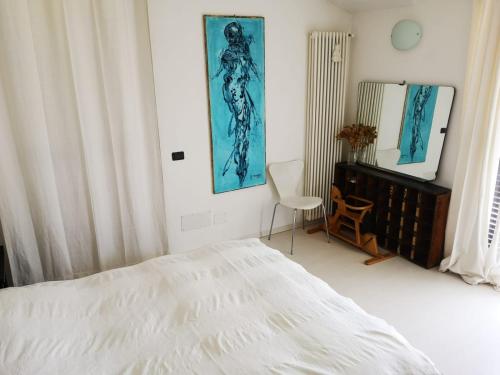 伦诺VILLA AS Campo Marzio的一间卧室配有一张床、一把椅子和镜子