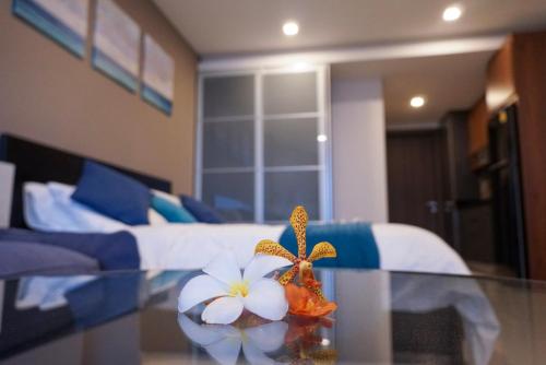 罗勇Beachfront Executive Studio Mae Phim的一间设有床铺和花卉玻璃桌的房间