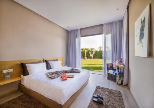 马拉喀什Palms Edge Villas avec Piscine & Jardin Privés的一间卧室设有一张床和一个大窗户