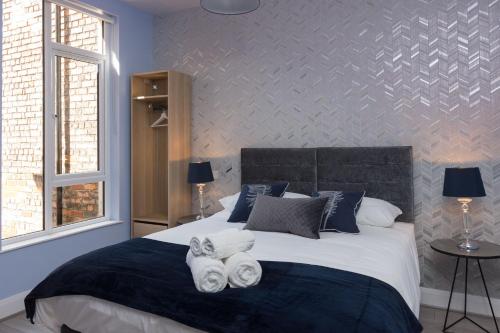 贝尔法斯特Titanic Guest Boutique, 4-Star Accommodation的一间卧室配有一张大床和毛巾