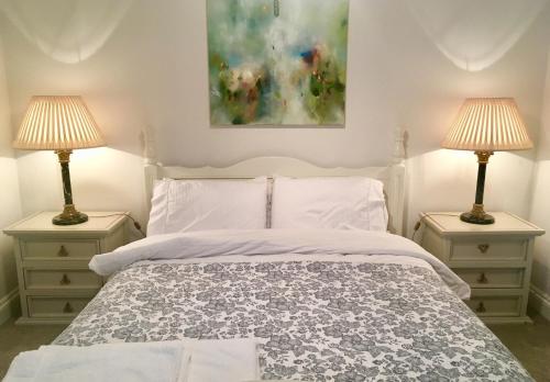 圣欧班Beautiful 1BR Apartment in Historic St Aubin House的卧室配有白色的床和两盏灯。