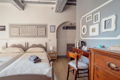 皮恩扎La Lanciotta的一间卧室配有两张床和一张桌子及椅子