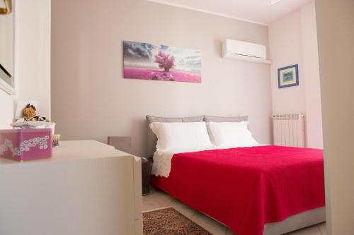 阿尔盖罗Viona Apartments的一间卧室配有一张带红色毯子的床