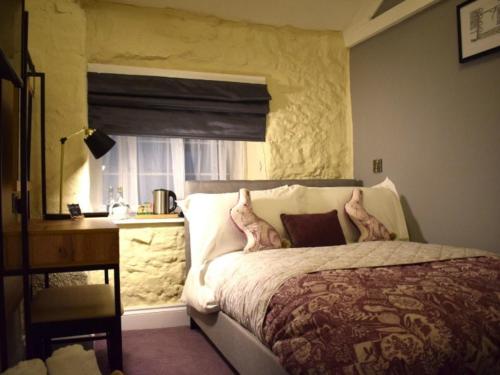BinegarThe Mendip Inn的一间卧室配有一张床、一张书桌和一个窗户。