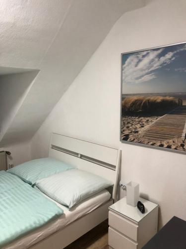 杜伊斯堡Wohnen auf Zeit的卧室配有一张床,墙上挂着一幅画