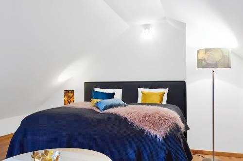 克维尔达Kvilda Apartments的一间卧室配有一张带蓝色棉被的床和一张桌子