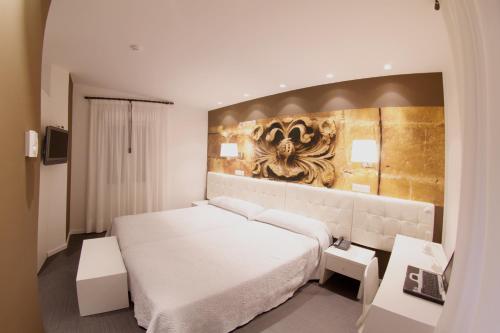圣比森特德拉松谢拉松斯厄拉别墅酒店的卧室配有白色的床和墙上的绘画作品