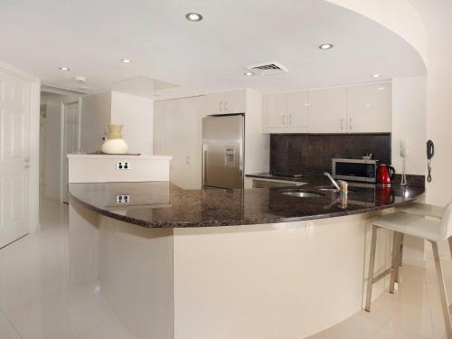 穆卢拉巴Zanzibar 404, Sensational 2 Bedroom Oceanview Apartment的厨房配有白色橱柜和花岗岩台面