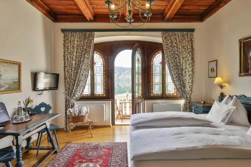 米尔施塔特希别墅酒店的卧室配有一张床、一张书桌和窗户。