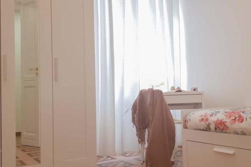 卡利亚里CASACRIZIA的一间卧室配有床和白色窗帘的窗户