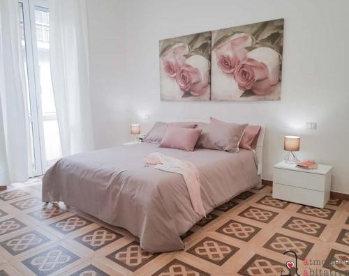 卡利亚里CASACRIZIA的卧室配有一张墙上有两朵粉红色玫瑰的床。