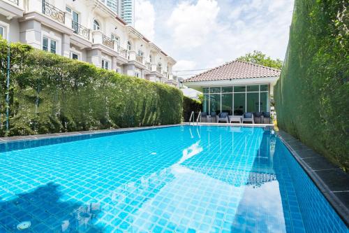 曼谷MIQ Asoke808 Villa - Asoke BTS - garden pool - 16 Pax的大楼前的游泳池