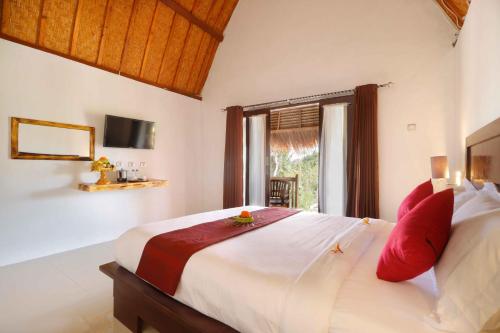 珀尼达岛Temeling Jungle Inn的一间卧室配有一张带红色枕头的床和一扇窗户