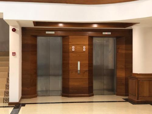 曼德勒Dragon Phoenix Hotel的大楼内带三部电梯的走廊