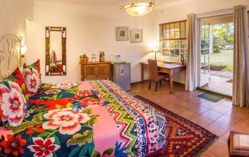 哈拉雷Jacana Gardens的一间卧室配有一张带彩色床罩的床