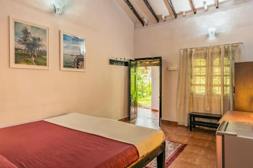 卡兰古特Rodrigues Guest House的一间卧室设有一张床,一扇门通往庭院