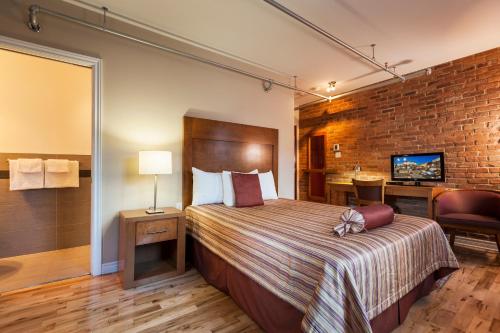 蒙特利尔阔特德斯派克特克酒店的酒店客房,设有床铺和砖墙