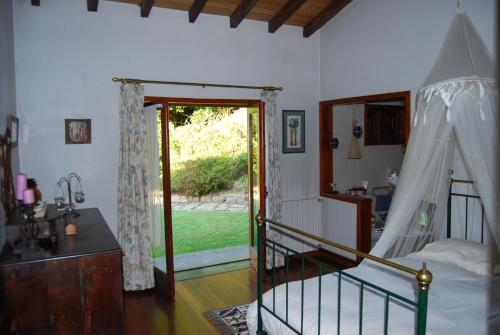 马尔科-德卡纳维泽斯Casa Dos Canais, River Cottage的一间卧室设有一张床和一个滑动玻璃门