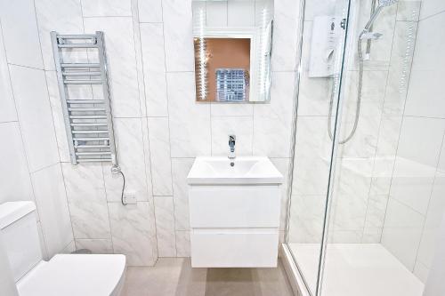 伦敦Eldon Chambers Pod 7 by City Living London的白色的浴室设有水槽和淋浴。