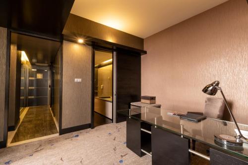 民都鲁新世界套房酒店的办公室,配有玻璃桌和灯