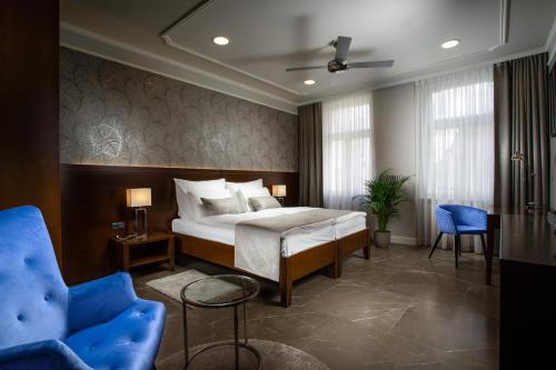 贝龙Hotel Anna的一间卧室配有一张床和一张蓝色椅子