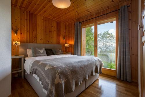 拉茨欧马兹Jacuzzi & Sauna | Chalet Teremok的一间卧室设有一张床和一个大窗户