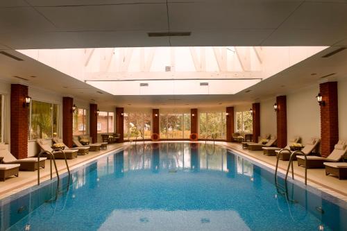 斯利那加拉利特大皇宫斯利那加酒店的酒店设有一个游泳池,配有椅子,还有一个大房间