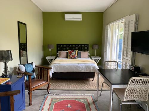 斯泰伦博斯Frida’s Place - Quiet in Stellenbosch Central的一间卧室设有一张床和绿色的墙壁