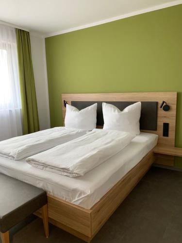 Klein-WinternheimWeingut Bugner Meizelhof的卧室配有一张带白色床单和枕头的大床。