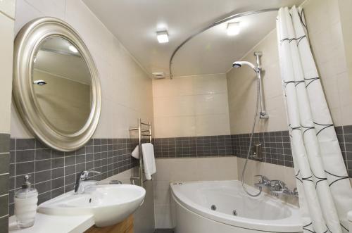 卡洛帕尼亚伊奥蒂斯卡斯特利公寓的一间带水槽、浴缸和镜子的浴室