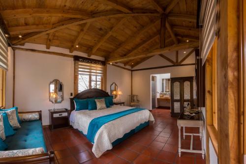 昆卡豪斯特里拉卡瓦略坎帕纳酒店的一间带一张大床的卧室,位于一个拥有木制天花板的房间