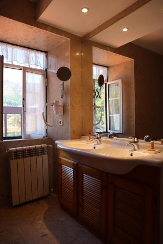 曼泰加什Alojamento Santa Clara的浴室设有2个盥洗盆、淋浴和镜子。