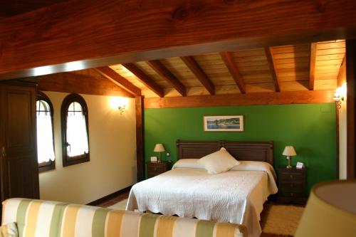 贝梅奥Eco Hotel Rural Lurdeia - Adults Only的绿色卧室设有床和2个窗户