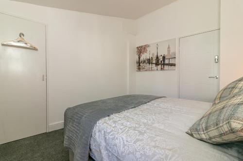 斯蒂夫尼奇Hillcrest Lodge的卧室配有一张床,墙上挂有绘画作品