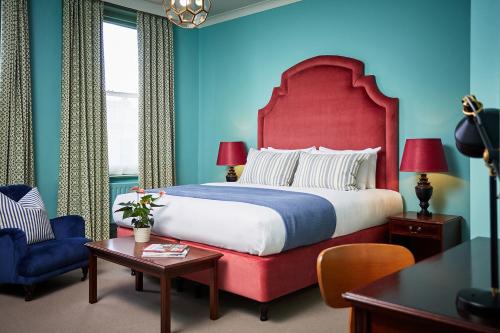 赫里福德The Green Dragon Hotel的一间卧室配有一张大床和红色床头板