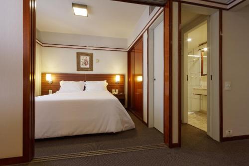 圣保罗Bristol The Time Berrini的卧室配有一张白色大床和镜子