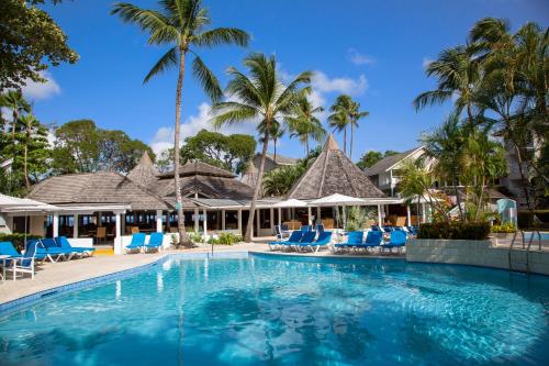 圣詹姆斯The Club Barbados - All Inclusive - Adults Only的度假村的游泳池,设有蓝色的椅子和棕榈树